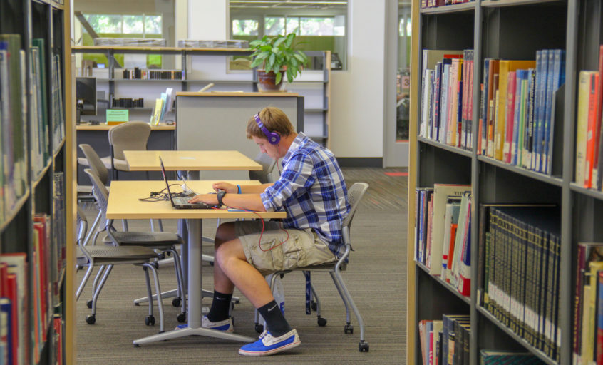Picture of male student studying at desk in library