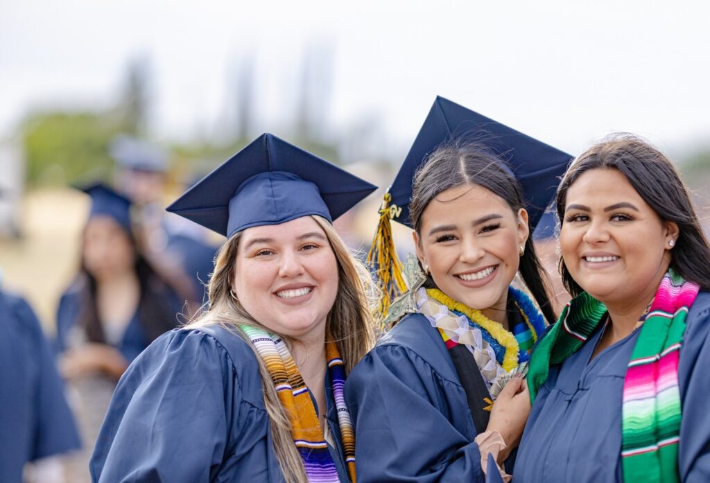 Three graduates smiling at camera from Yuba College Graduation